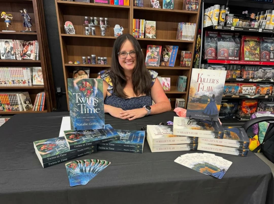 A self-published author at her own signing table, copies laid out in front of her
